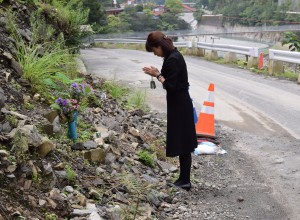 現場に花を供え、手を合わせる被災者家族=五條市大塔町