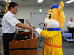 羽室英太郎本部長から「ナピちゃん」に任命書が手渡された