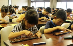 真剣な表情でそろばんをはじく参加者