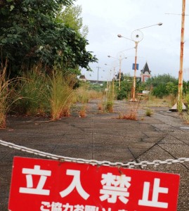 入り口には立ち入り禁止の看板がかかり、奥には手つかずのままの施設が見える