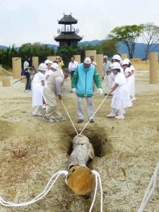 貫頭衣を着て柱を建てる体験学習に取り組む子供ら