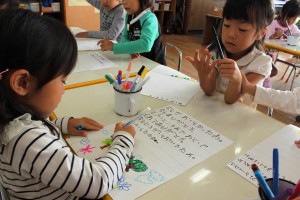 梨へのお礼の絵手紙を書く園児
