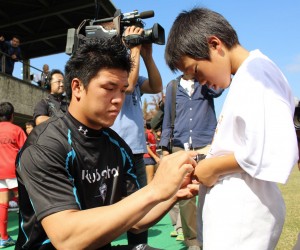 ファンにサインする立川理道選手。試合後に開かれた交流会では立川選手のサインを求め大勢の子供たちが列をなした