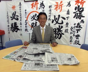 当選を報じた新聞各紙を前に会見する森下豊氏