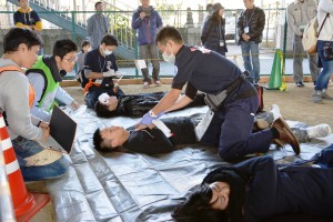 負傷者を診察し、治療の優先順位を決める参加チームの医師ら