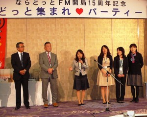 ならどっとFMの役員とともにあいさつに立つ中川直子社長(中央)
