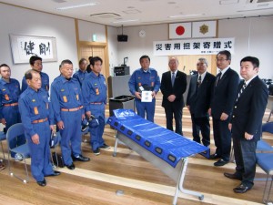 災害用担架の寄贈式に出席した五條市消防団員と五條ロータリークラブのメンバー