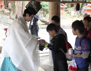 神職に菜種油を奉納する児童