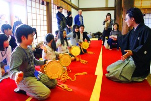 講師に教わりながら大鼓を打って能の魅力に触れる子供たち