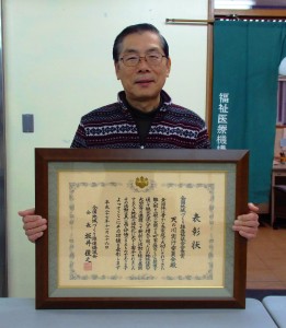 表彰状を手にする野村幸治代表