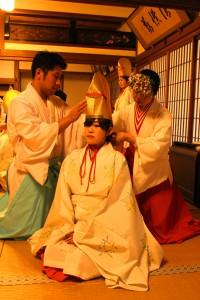 巫女や神職に衣装を着せてもらう福娘