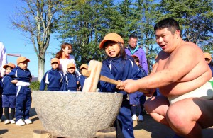 相撲部員の助けを借りながら餅をつく園児ら