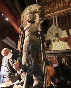 仏像に積もったほこりを払い落とす僧侶ら