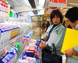 隔測温度計で牛乳パックの表面温度を検査する食品衛生監視員＝大和郡山市