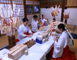 福矢や猿の一刀彫りなどの縁起物を準備する巫女ら