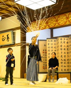 参加者の前で和紙で作られた「蜘蛛の糸」を投げる大槻裕一さん