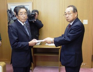 副町長から辞職届を受け取る辻一夫議長（左）