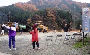 大きな円になりラジオ体操をする榛原檜牧自治会の住民（宇陀市提供）
