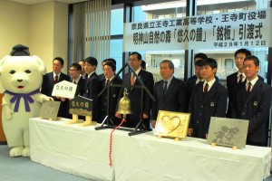 鐘を作製し平井康之町長に手渡した王寺工業高校の生徒ら