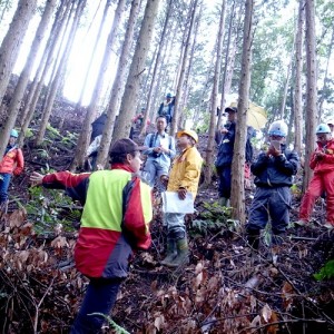 昨年６月にスイスの専門家を招いて行われた現地研修会。研修生は放置された人工林内で講義を受けた＝高取町