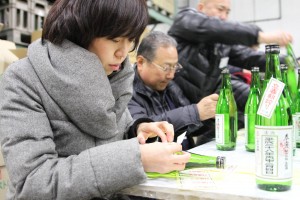 素早く丁寧にラベルを貼る酒販店関係者ら