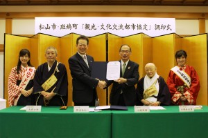 協定を締結し握手を交わす小城利重町長（中央右）と野志克仁市長