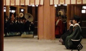 遷御を前に、幣殿前で儀式用具を持って待機する神職ら