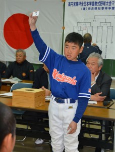 抽選会で番号札を上げる選手