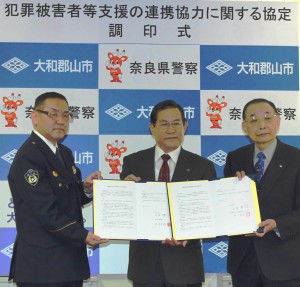 協定書に調印した（右から）西口廣宗理事長、上田清市長、弘末光則署長