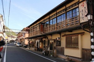 温泉旅館の2階の軒上部に掛けられたケヤキの看板。旅館の雰囲気に合わせた個性ある看板だ(奈良県提供)