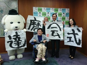 「達磨会式」の題字を王寺町に贈呈した書家、高岡哲也さん（中央）