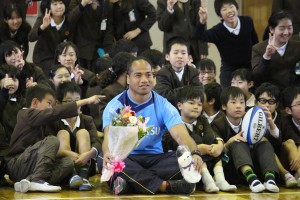 児童に囲まれて笑顔のタウファ統悦選手（中央）