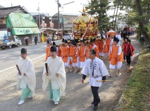 参道を神輿を担いで練り歩く氏子や神職ら