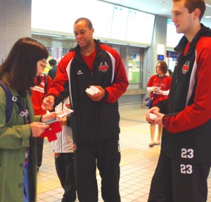 駅の利用者にチラシを配るヒンクル(中央)とリチャート(右)