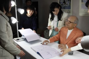 ひとりずつ丁寧にサインをする藤城清治さん(右)