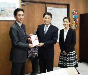 森下市長（左）に寄付金を手渡す浩明さん夫妻
