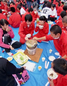 上級生が調理したすき焼きを食べる新入生