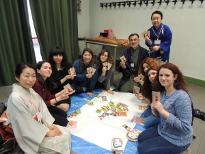 吉野杉で作られた百人一首の札を手にするイタリアの大学生ら=2月、イタリア・ローマ(日本文化研究所なら提供)