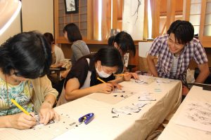 切り絵のワークショップでは来場者がデザインナイフを片手に真剣なまなざしで作品を制作していた