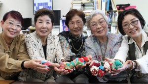 製作したお手玉を披露する「音楽の森」の荒井敦子理事長(右端)ら