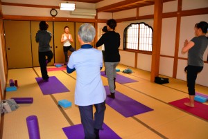 静かな寺の一室でヨガを体験する参加者ら