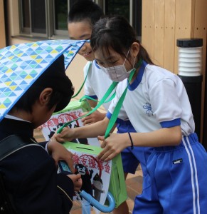 雨の降る中でも募金箱を両手に「支援募金にご協力お願いします」と大きな声で呼び掛ける児童