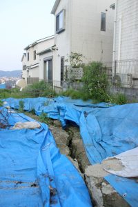 業者が無許可で盛り土をしていた斜面。亀裂が広がり、現在は防水シートで保護されている