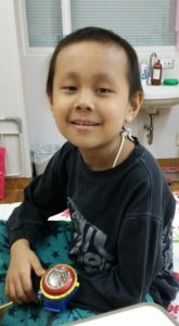 病室で笑顔を見せる平尾吏覇君＝平成２６年１０月、三重県津市