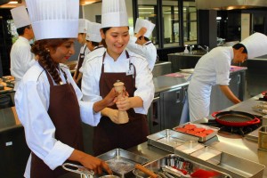 指導を受けながらフランス料理の調理に挑戦する参加者