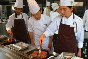 指導を受けながらフランス料理の調理に挑戦する参加者