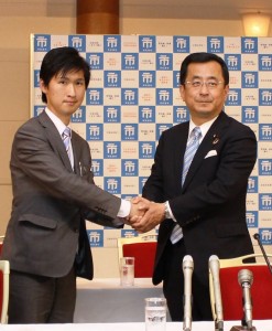 握手を交わす前川清成氏（右）と共産党の和泉信丈氏