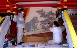 春日大社本殿の板塀に描かれた壁画「獅子牡丹図」を慎重にはぎ取る技師ら
