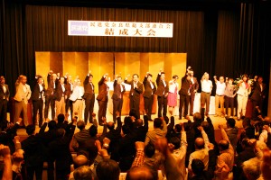 党の新たな歩みを誓いガンバローコールをする出席者ら