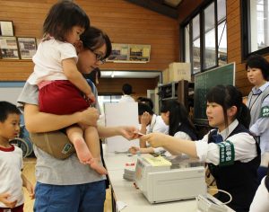 投票に訪れた市民に投票用紙を交付する生徒